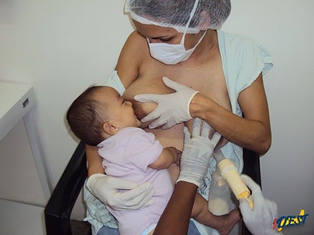 Enquanto Michele Maximino amamenta a filha, técnica extrai leite do outro seio
